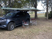 Dark-colored SUV with 30 Second 180 Degree Wing Awning rooftop canopy for outdoor shade