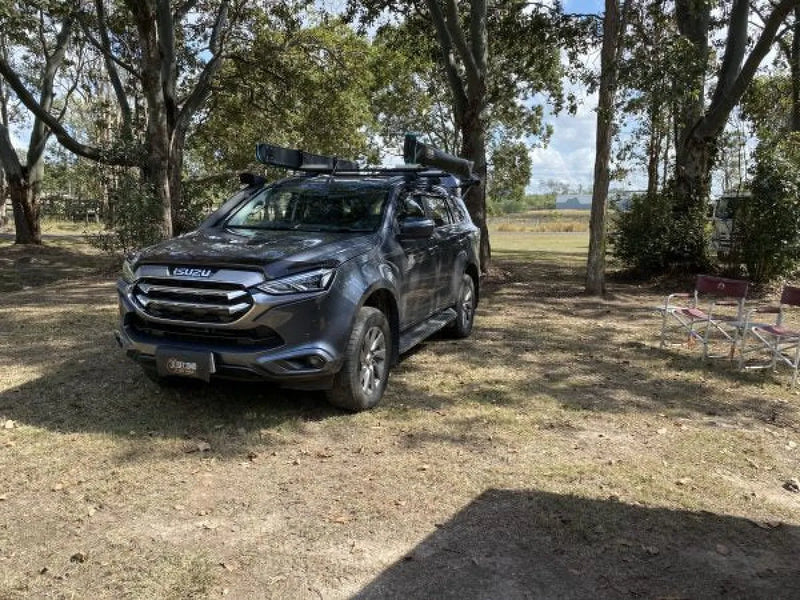 Gray Ford SUV with roof rack parked under trees showcasing 30 Second 180 Degree Wing Awning