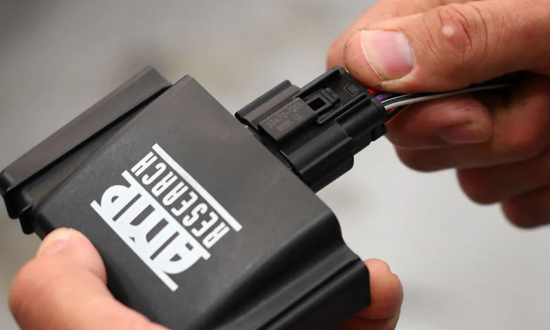 Tuning chip device plugged into PowerStep Smart Series port for AMP Research PowerStep Smart