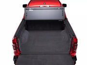 BAKFlip MX4 folded up against the cab of a red RAM 1500, showing the open tub from behind