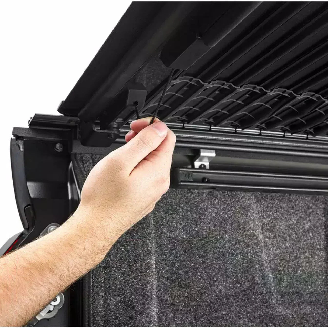 Hand operating the BAK Revolver X4TS cover from the side of the tub