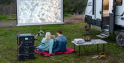 Couple enjoying an outdoor movie with Bluetti AC180P Solar Portable Power Station