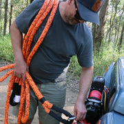 Bright orange Carbon Offroad kinetic recovery rope draped over a person’s shoulder