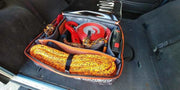 Coiled yellow rope or tow strap in red gear cube storage bag with emergency gear