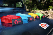 Colorful elastic resistance bands with branded tags for Monkey Fist Rope products on reflective surface