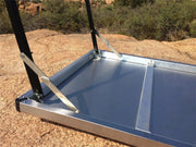 Solar panel mounted on an adjustable frame with support straps on Eezi-Awn K9 large stainless steel camping table