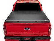 Red Ford pickup truck with a black soft folding truck bed cover for Ford F-150