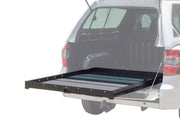 Sliding truck bed cargo slide extending from SUV for organized load bed cargo storage