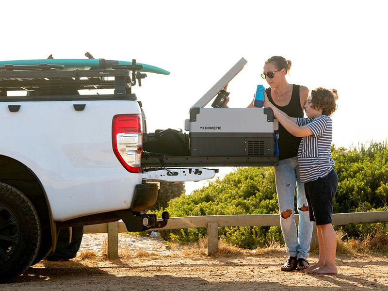 Portable refrigerator being loaded into a Pickup Truck with Front Runner Load Bed Cargo Slide