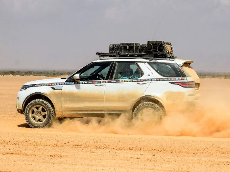 Land Rover SUV with Front Runner LR All-New Discovery 5 roof rack kit driving in desert