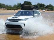 White Land Rover SUV driving through water with Front Runner LR Discovery 5 roof rack kit