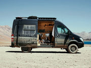 Converted Mercedes Benz Sprinter camper van with open side door showcasing cozy interior and Slimline II Tray