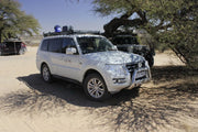 White Mitsubishi Pajero SUV with police lights and Slimline II Tray roof rack kit