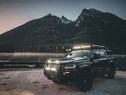 Rugged off-road vehicle with LED light bar and roof lights near mountains