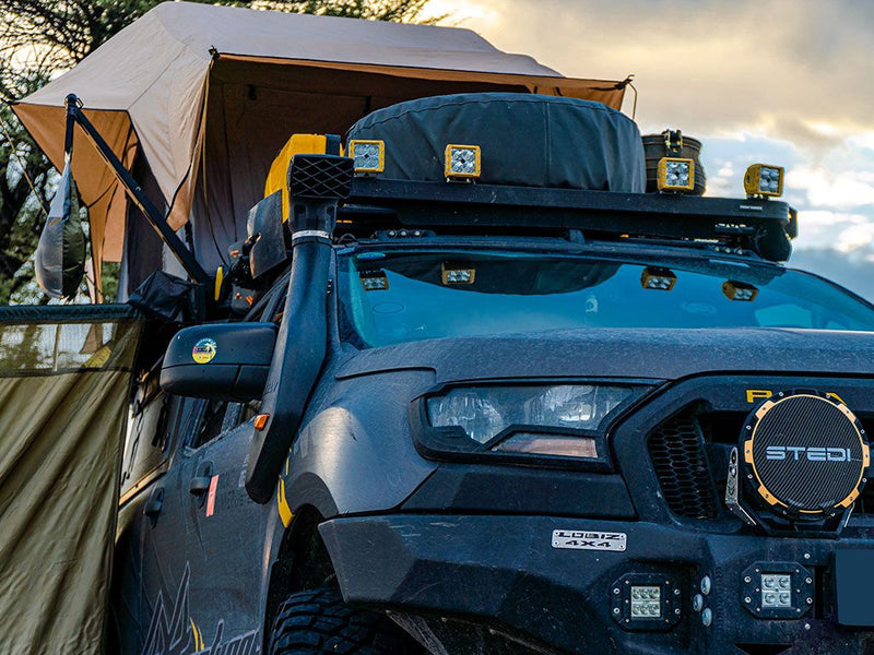 Blue off-road vehicle with roof rack and shower arm mounted on Runner Roof Rack next to roof tent