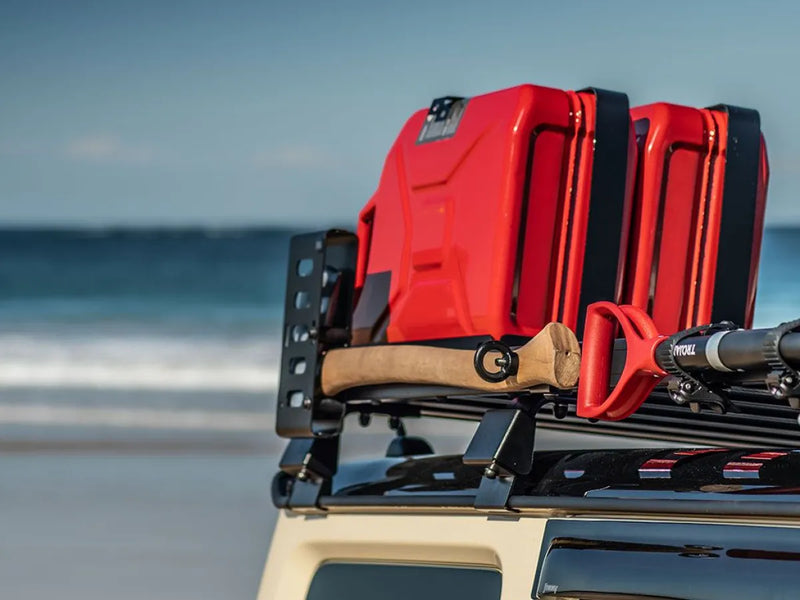 Red plastic fuel canisters secured with Front Runner Roof Rack Axe Bracket on Slimline II Roof