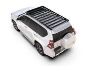 White SUV with slimsport rack kit and roof rack viewed from above behind Toyota Prado