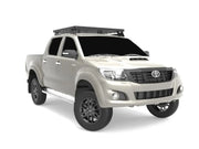White Toyota Hilux pickup truck with Slimline II tray roof rack kit and off-road tires