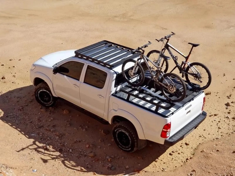 White pickup truck with bicycle on roof rack from Front Runner Toyota Hilux Slimline II roof rack kit