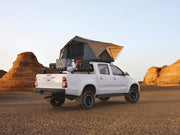 White pickup truck with rooftop tent on Slimline II tray roof rack kit for Toyota Hilux