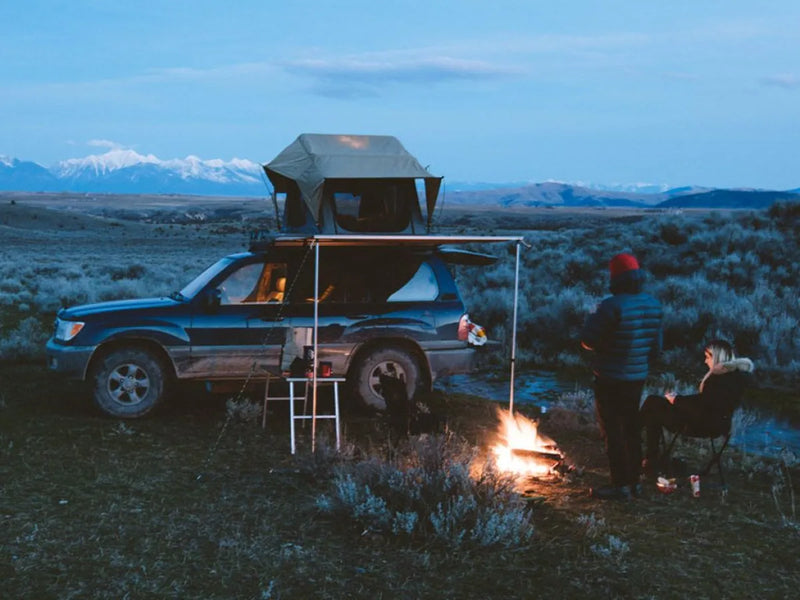 SUV with rooftop tent on Front Runner Land Cruiser rack kit in camping setting