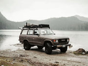 Vintage Toyota Land Cruiser SUV with Front Runner Roof Rack Kit by a lake