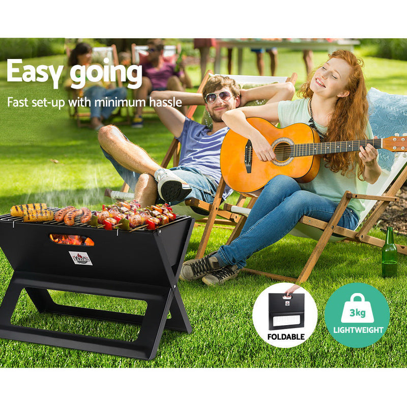 Portable charcoal BBQ grill with food cooking on the Grillz Notebook Portable Charcoal BBQ
