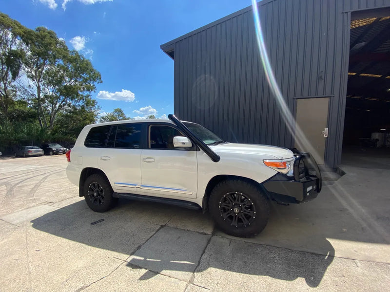 White Toyota Land Cruiser with black off-road wheels and front bull bar showcasing stainless steel snorkel kit