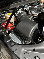 Car engine compartment showing air intake system with stainless steel 5th gen snorkel kit