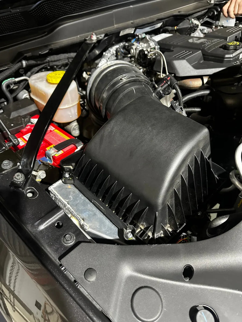 Car engine compartment showing air intake system with stainless steel 5th gen snorkel kit