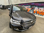 Toyota Land Cruiser with front-end damage and graffiti wall showcasing stainless steel snorkel kit