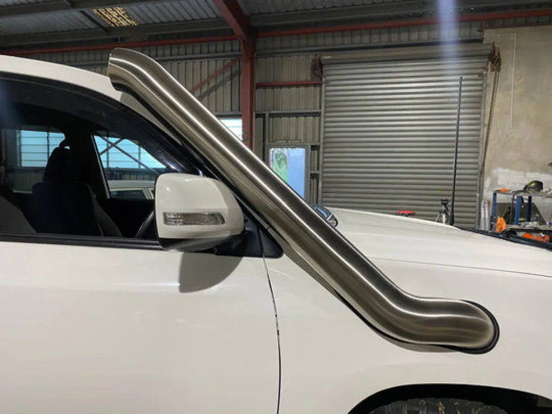 Stainless steel snorkel attachment on side of white Toyota 200 Series Landcruiser for off-road protection