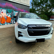 White Isuzu DMAX pickup truck with stainless steel snorkel parked near graffitied wall