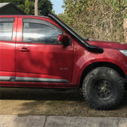 Red pickup truck with oversized off-road tires showcasing Meredith stainless steel snorkel kit