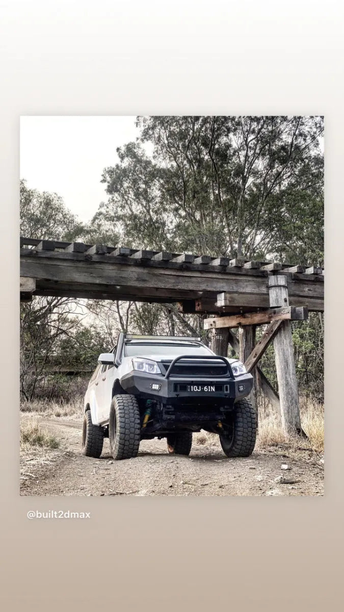 Modified off-road truck with oversized tires under wooden structure showcasing Stainless Steel Snorkel Kit