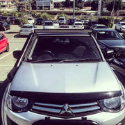 Silver Mitsubishi pickup truck with steel snorkel and roof-mounted light bar