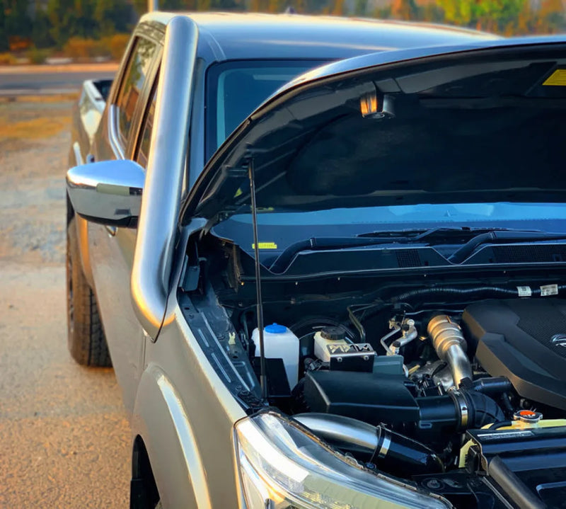 Car with open hood showing engine, featuring Meredith stainless steel snorkel kit for Navara