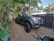 Gray pickup truck with oversized off-road tires featuring Meredith stainless steel snorkel kit