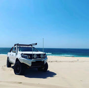 Off-road pickup truck with stainless steel snorkel parked on sandy beach