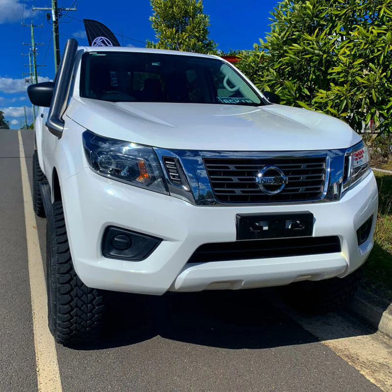 White Nissan pickup truck with prominent front grille and headlights featuring stainless steel snorkel