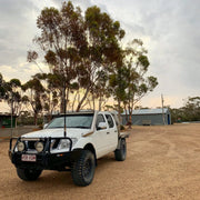 White off-road pickup truck with stainless steel snorkel and oversized tires