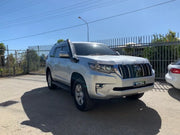 Silver Toyota Land Cruiser SUV with stainless steel snorkel on paved surface