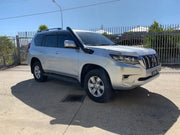 Silver Toyota Land Cruiser Prado SUV with stainless steel snorkel parked on concrete