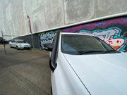 White car parked in front of graffiti wall showcasing Meredith stainless steel snorkel kit for Toyota Prado