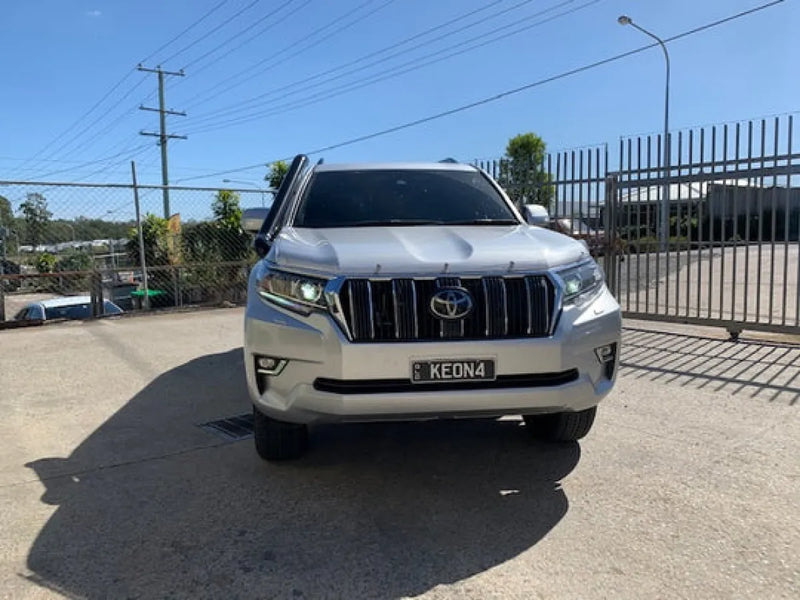 White Toyota Land Cruiser Prado SUV with stainless steel snorkel and prominent front grille