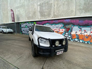 White off-road vehicle with stainless steel snorkel parked in front of graffiti wall