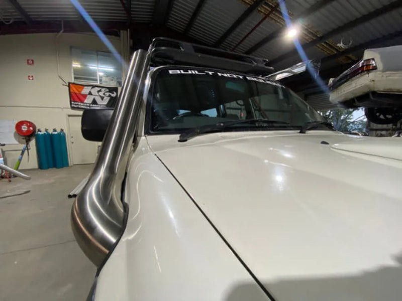 White pickup truck with a prominent stainless steel snorkel air intake for Toyota 80 Series Landcruiser