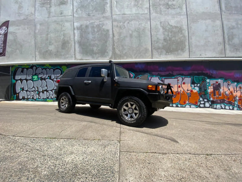 Black SUV with stainless steel snorkel parked in front of graffiti wall for Toyota FJ Cruiser