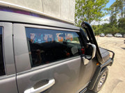 Silver off-road vehicle with colorful stickers showcasing Meredith stainless steel snorkel kit for Toyota FJ Cruiser