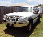 White Nissan Patrol GU Y61 SUV with bull bar and roof rack featuring extendable towing mirrors